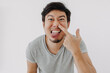 Asian man make funny teasing face for humor isolated on white.