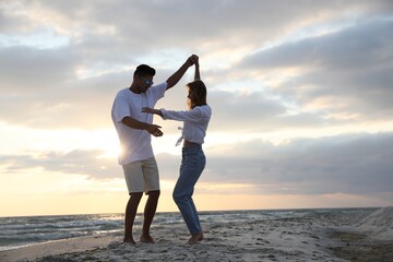 Poster - Happy couple dancing on beach at sunset