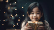 Pretty little Asian children girl smile with Christmas gift box with blurred bokeh background.