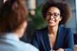 Cheerful African American businesswoman in eyeglasses with kinky hair smiles greeting colleagues. Joyful young woman in formal wear shakes hand of co-worker. Business lady meets new employees