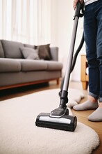 Caucasian Man Uses Vacuum Cleaner To Keep Living Space Tidy. Man With Vacuum Cleaner In Hand Ensures Home Remaining Tidy Place To Live. Vertical Photo.