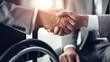 Disabled job candidate in a wheelchair shaking hands with a employer. Inclusive and equal opportunities in the workplace