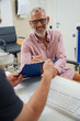 © Svitlana - Bearded elderly man signing documents in doctors office