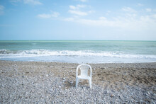 Scenic view of single plastic chair against sea