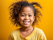 beaming mixed race child radiates joy and happiness against a vibrant yellow background