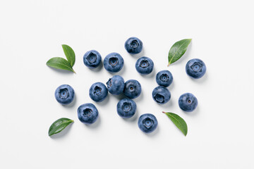 Tasty fresh blueberries with green leaves on white background, flat lay