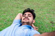 © Kiran - Happy moment of a handsome young boy taking selfie on grass background