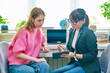 Counselor talking with teenage girl, using digital tablet for work