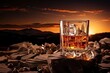 Glass of whisky with ice cubes on rocky landscape