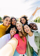 © Xavier Lorenzo - Multiracial group of seven cheerful women having fun taking selfie portrait. Female friendship concept with millennial girls enjoying free time at city street. Integration and happy people concept