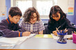 © Austockphoto - Three school students sitting at their desk in the classroom working