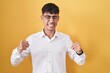 © Krakenimages.com - Young hispanic man standing over yellow background excited for success with arms raised and eyes closed celebrating victory smiling. winner concept.