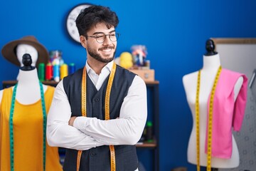 Canvas Print - Young hispanic man tailor smiling confident standing with arms crossed gesture at sewing studio