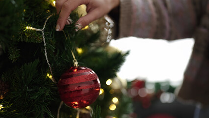 Wall Mural - Young blonde woman decorating christmas tree at home