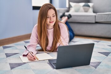 Poster - Young caucasian woman lying on floor studying at home