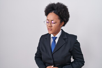 Poster - Beautiful african woman with curly hair wearing business jacket and glasses with hand on stomach because indigestion, painful illness feeling unwell. ache concept.