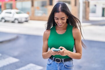 Wall Mural - Young beautiful hispanic woman smiling confident using smartphone at street