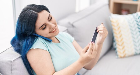 Poster - Young caucasian woman talking on the smartphone doing manicure at home