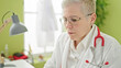 © Krakenimages.com - Middle age grey-haired woman doctor using laptop working at clinic