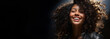 Mixed race black woman. Beauty shot super happy girl laughing. Portrait of young afro-american woman with curly hair looking at camera and smiling on blurred inside background. Copy space