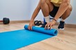 © Krakenimages.com - Young arab man rolling up yoga mat at sport center