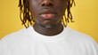 African american man close up of serious expression over isolated yellow background