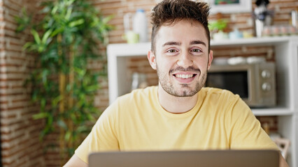 Sticker - Young hispanic man using laptop sitting on table at dinning room