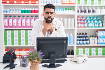 Wall Mural - Hispanic man with beard working at pharmacy drugstore shouting and suffocate because painful strangle. health problem. asphyxiate and suicide concept.