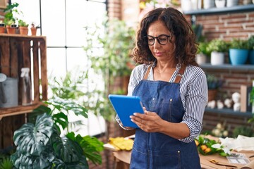 Sticker - Middle age woman florist using touchpad at flower shop