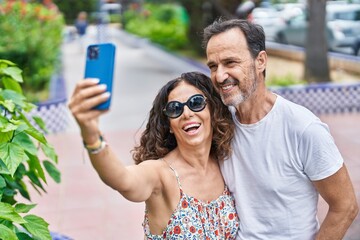 Poster - Man and woman couple hugging each other make selfie by smartphone at park