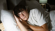 © Krakenimages.com - Exhausted young hispanic man finds comfort in a bright morning sleep, lying undisturbed in his cozy bedroom, surrendering to the soft embrace of his bed and pillow, in a relaxed indoor portrait.