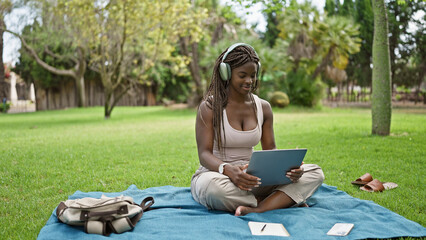 Poster - African american woman student using laptop and headphones at campus university