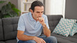 © Krakenimages.com - Middle age man sitting on sofa with serious expression at home