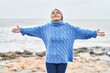© Krakenimages.com - Middle age grey-haired woman smiling confident standing with arms open at seaside
