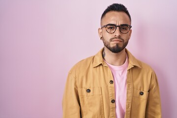 Canvas Print - Young hispanic man standing over pink background skeptic and nervous, frowning upset because of problem. negative person.