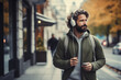 Lifestyle, hobbies and leisure, technology concept. Gorgeous man with headphones walking in park during autumn and listening music. Sunny fall day