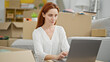 © Krakenimages.com - Young redhead woman using laptop sitting on floor at new home