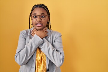 Poster - African american woman with braids standing over yellow background shouting and suffocate because painful strangle. health problem. asphyxiate and suicide concept.