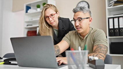 Wall Mural - Man and woman business workers working together using laptop at the office