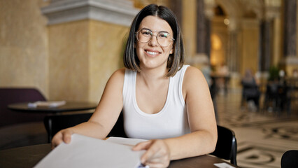 Sticker - Young beautiful hispanic woman wearing glasses smiling happy reading menu at cafeteria