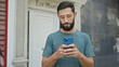 © Krakenimages.com - Young hispanic man using smartphone with serious expression at street
