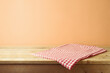 © maglara - Empty wooden table with red checked tablecloth over modern beige background.  Kitchen mock up for design and product display