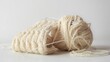 Closeup of a yarn of beige thread on  a white background