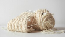 Closeup Of A Yarn Of Beige Thread On  A White Background