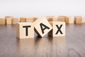 Sticker - tax text on wooden blocks. wooden background. foreground