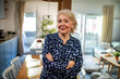 © Marko Geber - Confident senior woman standing at home looking at camera