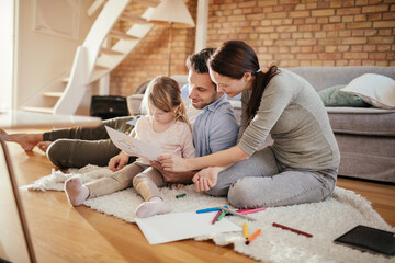 Young family drawing on the floor