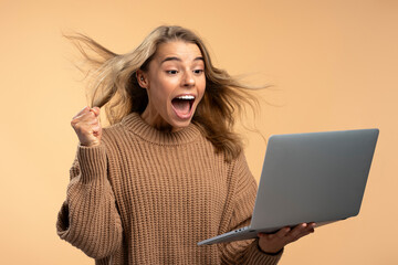 young overjoyed woman holding laptop shopping online. shopping, sale black friday concept. happy bea