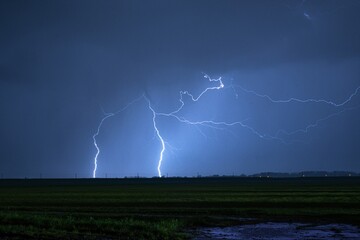 Wall Mural - frightening shot of striking thunderbolts during a stormy night