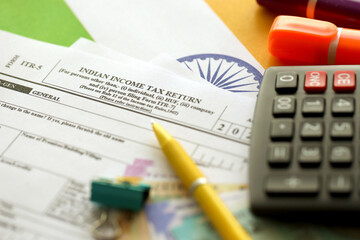 Indian income tax return blank form with pen and indian rupees bills on indian country flag close up. Annual tax report concept